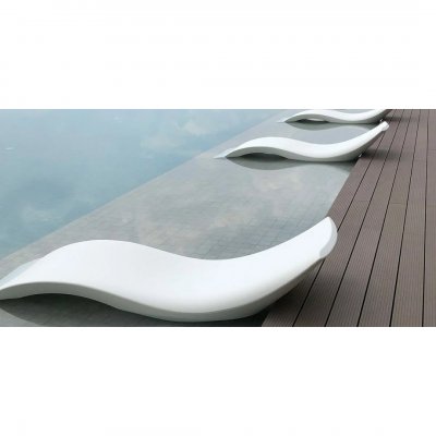 Белые волнообразные шезлонги у бассейна на тёмной композитной террасе.